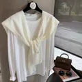 Dettaglio dello scialle in maglia di lana beige con trama a coste su t-shirt bianca - Bianco Sporco