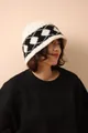 Detailed close-up of geometric diamond pattern on thick wool knitted winter hat - White