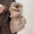 Detail of wool blend scarf showing rib-knit texture and material composition label - Oatmeal Beige