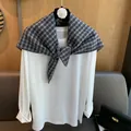 Detail of vintage gray plaid triangle scarf draped over a white long sleeve cotton top - Black