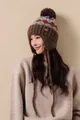Detail of vintage Fair Isle knit hat with plush faux fur pompom and warm earflaps - Coffee