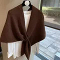 Detail of dark brown knitted wool blend shawl with a textured cross-loop closure design - Coffee