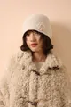 Detailed knit texture of beige crochet flower beanie with cozy wool coat style - Cream Rice
