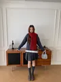 Full view of model wearing a red wool blend fringe scarf with a gray knit sweater - Red