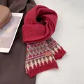 Primer plano detallado de bufanda de punto roja con motivos nórdicos y parche de cuero - Rojo