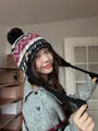 Detail of bohemian knit trapper hat with geometric patterns, earflaps and tassels - Black