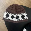 Detail of 100% wool knit tag on thick winter beanie with nordic geometric pattern - Coffee
