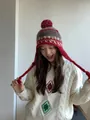 Detail of ethnic knit earflap hat with colorful pom-poms and vintage geometric patterns - Red