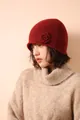 Primer plano del detalle de flor de ganchillo hecha a mano en gorro de punto - Rojo