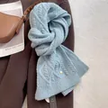 Close-up van lichtblauwe kabelgebreide merino wollen sjaal met kleurrijke spikkels - Baby Blauw