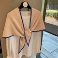 Chal de punto 100% lana beige con ribete azul, mostrado con un nudo frontal elegante - Borde Beige