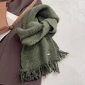 Detail of dark green knit scarf with sequins, fringe edges, and small metal logo - Dark Green