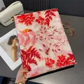 Dettaglio della sciarpa in cotone e lino rosa con motivi floreali rossi e dorati - Rosso