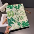 Detail of leaf print scarf with golden edges and delicate fringe trim textures - Green