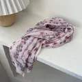 Detalle de bufanda de gasa plisada rosa con textura arrugada y estampado floral - Rosa