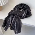 Détail de l'écharpe en coton avec motifs floraux marron et texture de tissu doux - Café Brun