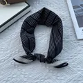 Close-up of black and white striped silk cotton neckerchief with elegant knotted styling - 70x70cm / Wave Black