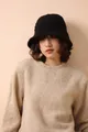Primer plano detallado de un gorro de lana merina de punto grueso negro en una modelo - Negro