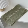 Macro detail of olive green cotton-linen scarf with white butterfly embroidery pattern - Green
