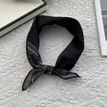 Detalle de pañuelo negro de seda y algodón con estampado paisley blanco en los extremos - Negro