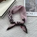 Detail shot of navy blue silk-like scarf with rose and butterfly patterns tied in a knot - Pink Flower Vine
