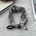 Macro detail of silk-cotton neckerchief featuring classic black paisley and contrast border - 70x70cm / Paisley White
