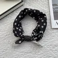 Detail of silk scarf tied in a bow featuring elegant black and white polka dot patterns - 70x70cm / Polka Dot