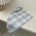 Blue and white checkered cotton scarf with small white fabric label on white surface - Blue and White Plaid