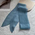 Vue détaillée d'une écharpe en soie plissée bleu gris sur dentelle blanche - Bleu Sel de Mer