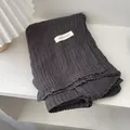 Close-up of dark grey crinkle cotton linen scarf with ABOUT AUTUMN fabric label - Marl Grey