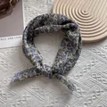 Detail eines Vintage-Baumwoll-Kopftuchs mit floralem Muster und elegantem Knotendesign - Blaues Blumenmuster