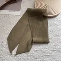 Detail eines olivgrünen Plissee-Schals mit eleganten Falten und spitzen Enden - 130*9cm / Kaffeebraun