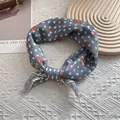 Detail of blue floral silk scarf featuring red cherry patterns and fine hemmed edges - 58cm x 58cm / Polka Dot