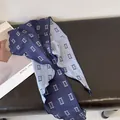 Sciarpa lunga in seta blu navy e grigio chiaro con motivo geometrico su panca in pelle - Blu + Blu chiaro