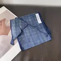 Detail of navy blue linen scarf fabric with fine edge stitching and material tag - Dotted Plaid Blue