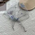 Detailed close-up of delicate floral embroidery on gray mesh lace triangle headscarf - Gray