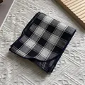 Dettaglio di sciarpa in cotone a quadretti bianco nero con bordo blu scuro rifinito - Quadri Grandi Nero