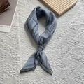 Macro shot of grey-blue pleated scarf with refined stitching on woven background - 70x70 / Blue