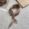 Detail of tied silk-texture scarf with brown tie-dye patterns on a white background - 70x70 / Orange