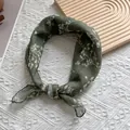 Detail of dark green floral cotton linen small square scarf tied in a stylish knot - Green
