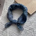 Close-up of blue paisley cotton-linen scarf tied in a knot on minimalist background - Navy Blue