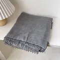 Détail d'une écharpe en coton et lin gris avec bordure ondulée perlée et texture - Gris clair