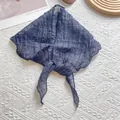 Détail d'un foulard en lin bleu marine à carreaux avec bords ondulés sur fond texturé - Bleu marine