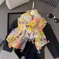 Detail van kleurrijke sjaal met tropische verenprint en decoratieve lange kwastjes afwerking - Kwastjes Stijl