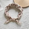 Dettaglio di un foulard in seta beige a pois marroni annodato con eleganza - Quadrato / Bianco Sporco