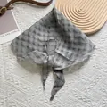 Detail of grey plaid linen triangle scarf with breathable pleated texture and tied knot - Gray