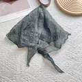 Detail of grey-green linen neckerchief showing delicate lattice pattern and wavy edge - Green