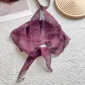 Gros plan d'une écharpe légère bordeaux à carreaux avec texture en lin sur tissu blanc - Bordeaux