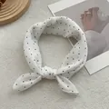 Classic white silk scarf with black polka dots styled on a wooden tray with decor - White