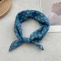 Close-up of knotted blue paisley print cotton linen scarf with silky texture detail - Sea Salt Blue